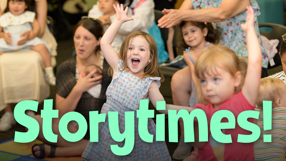 young kids being active and enjoying themselves at a storytime with a few parents in view