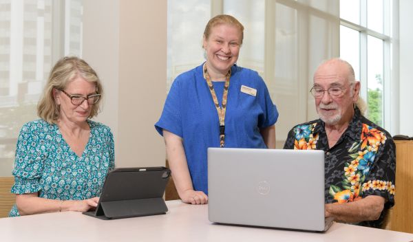 Librarian working with two customers on computers