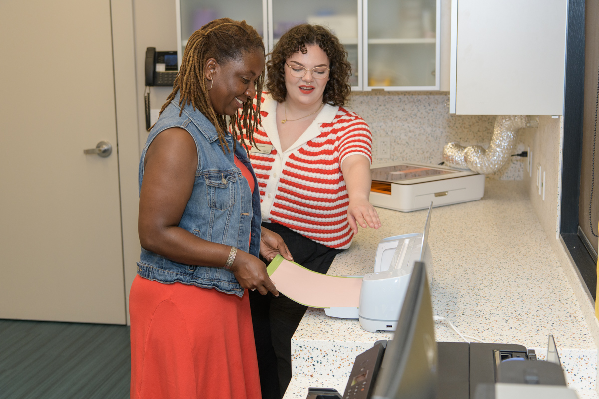 library staff demonstrate cricut machine to a customer