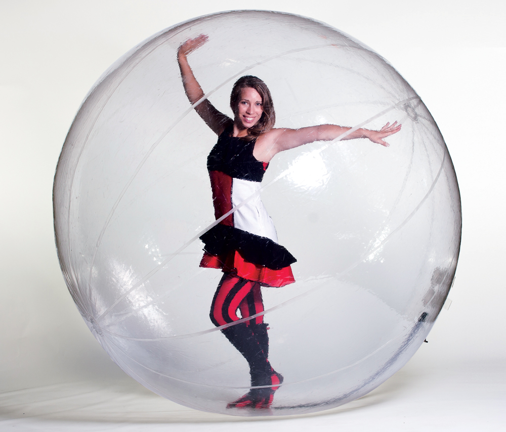 smiling woman posing inside a plastic ball prop