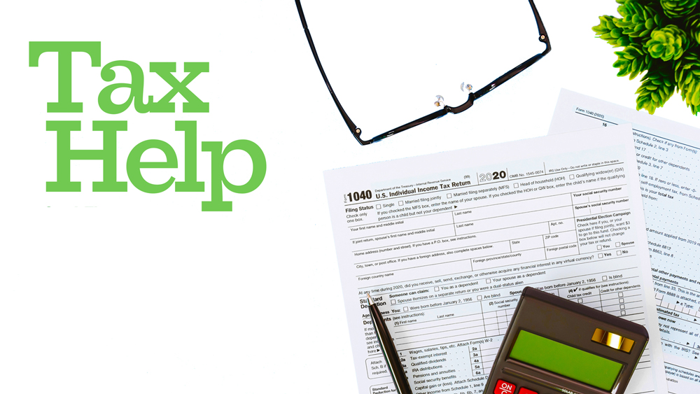 tax forms, pen, calculator, glasses shown from above, with 